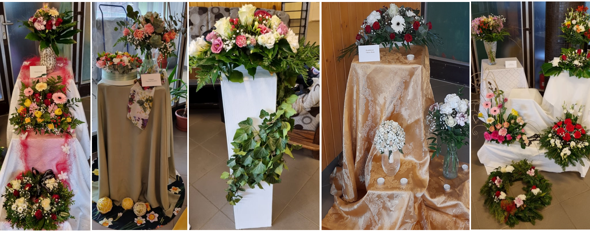 Öt dekoratív temetési virágkompozíció, mindegyik egyedi tervezésű és állványokon, jól megvilágított beltéri környezetben, különféle színű és típusú virágokkal.