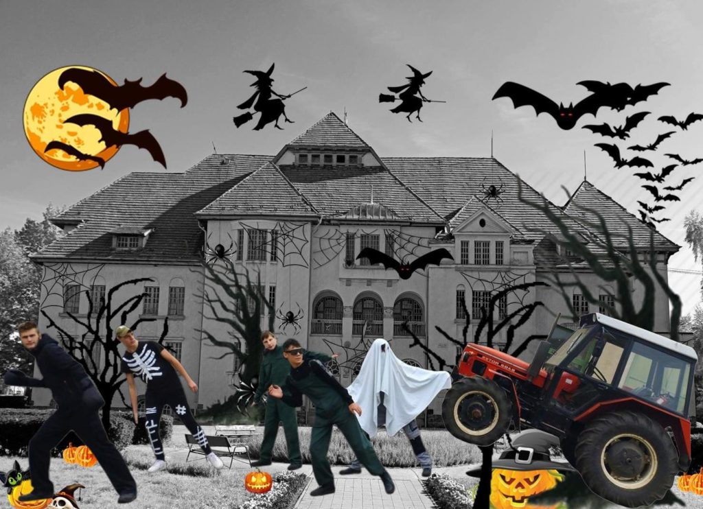 Egy halloween témájú kép, amelyen ügynöknek öltözött emberek kísértetet üldöznek egy kísérteties kastély előtt, a közelben denevérekkel és sütőtökökkel.