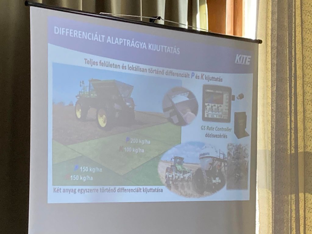Vetítőképernyő, amely bemutat egy diát a mezőgazdasági differenciálműtrágyázásról, egy szántóföldi traktor képeivel, egy gps rc vezérlővel és két adattáblázattal.