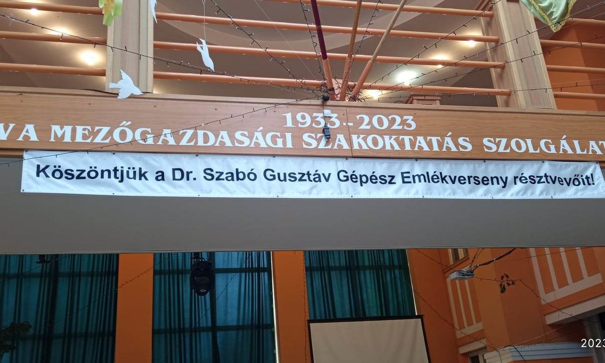 A teremben függő transzparens a "90 év az agrároktatás szolgálatában, 1933-2023" emlékére, és köszönetet mond a jelenlévőknek a dr. szabo gustav emlékrendezvény.