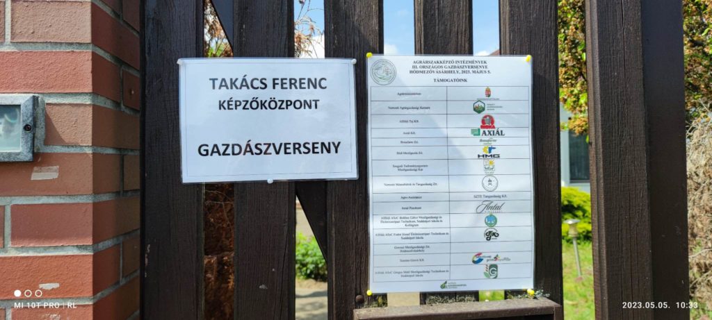 Két információs tábla egy intézményen kívüli fémkapun, az egyik a különböző magyar nyelvű szakmai képzési programokat és a partnerszervezetek logóit sorolja fel.