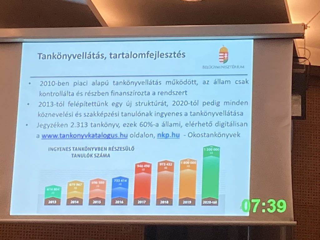 Prezentációs dia képe grafikonokkal és szöveggel. A dia bemutatja a magyarországi tankönyvellátás alakulását 2010-től 2020-ig. Az oszlopdiagramon 2014-től 2020-ig látható az ingyenes tankönyvben részesülő tanulók száma. A jobb alsó sarokban egy digitális óra 07:39-et mutat.