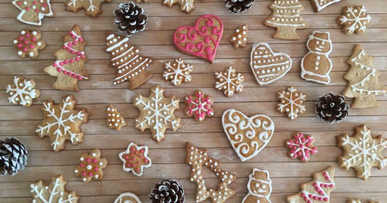 A fából készült asztalt díszített karácsonyi sütemények és fenyőtobozok díszítik. A sütemények hópelyhek, karácsonyfák, szívek és hóemberek formájúak, bonyolult fehér, rózsaszín és sárga cukormázmintákkal.