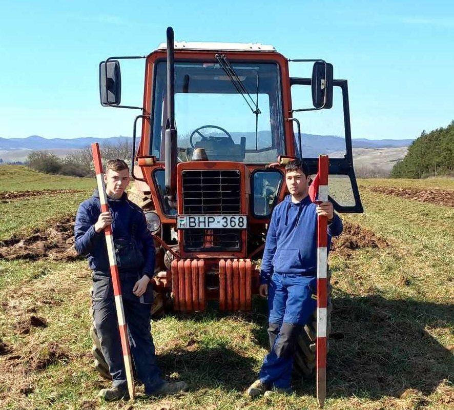 Két mezőgazdasági gépész tanuló egy traktor előtt